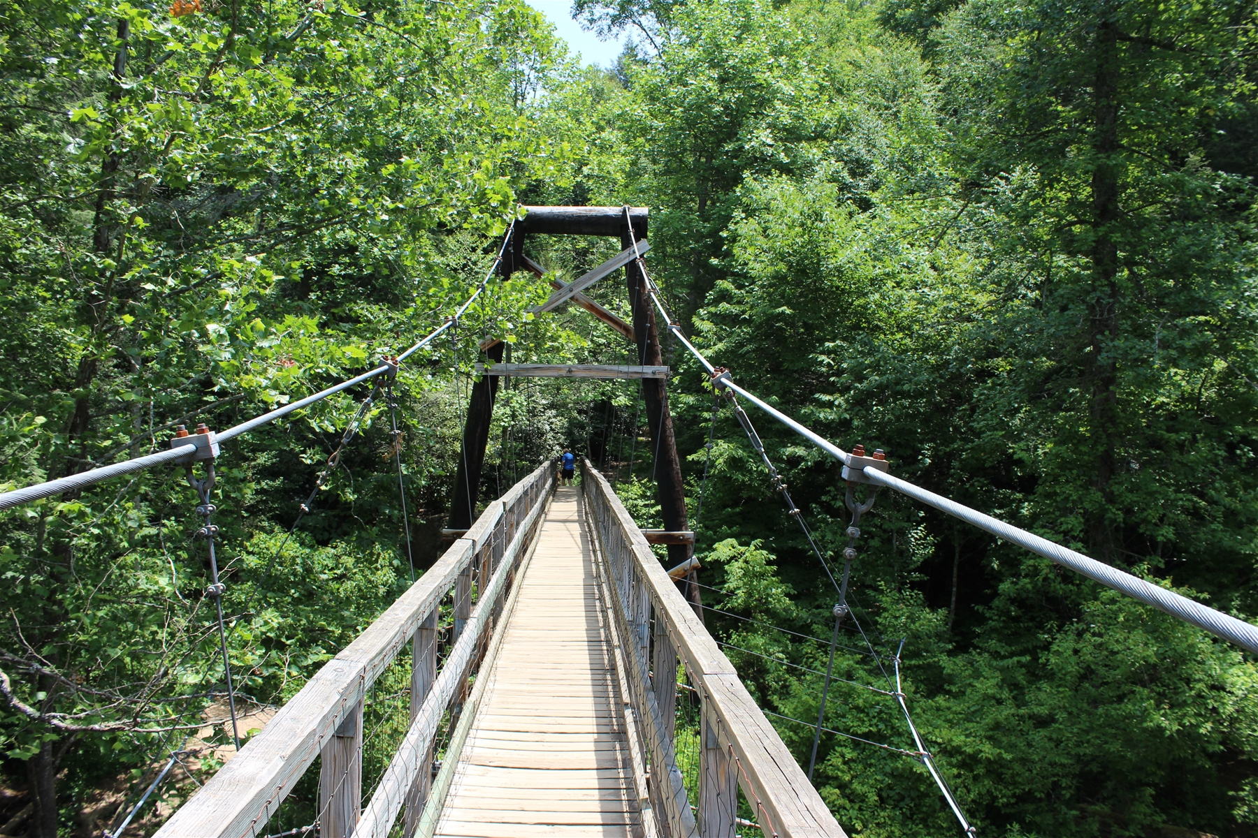 Person crossing the Toccoa River on the Swinging Bridge